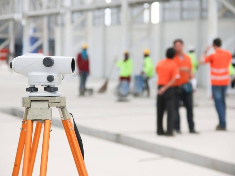 Construction survey instrument positioned on an active job site to verify layout accuracy and support ongoing construction work.