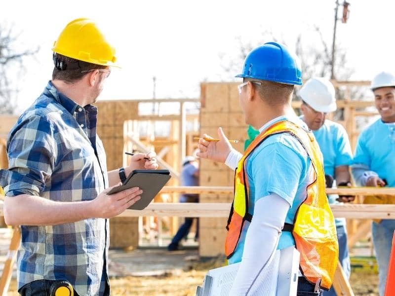Construction and land surveying professionals coordinating residential development plans before building begins.
