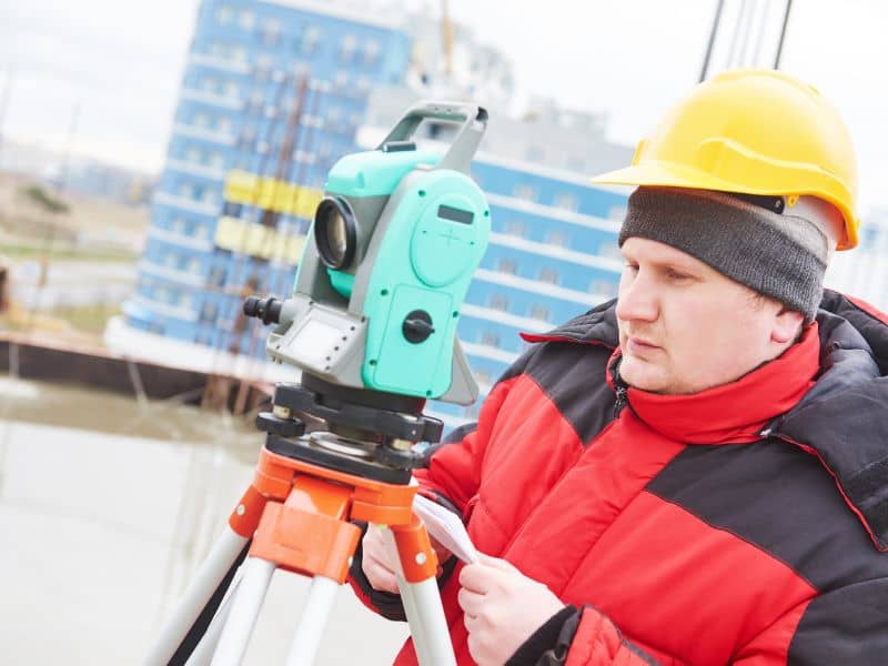 Construction surveyor using a total station for podium apartment construction in Fort Worth, Texas